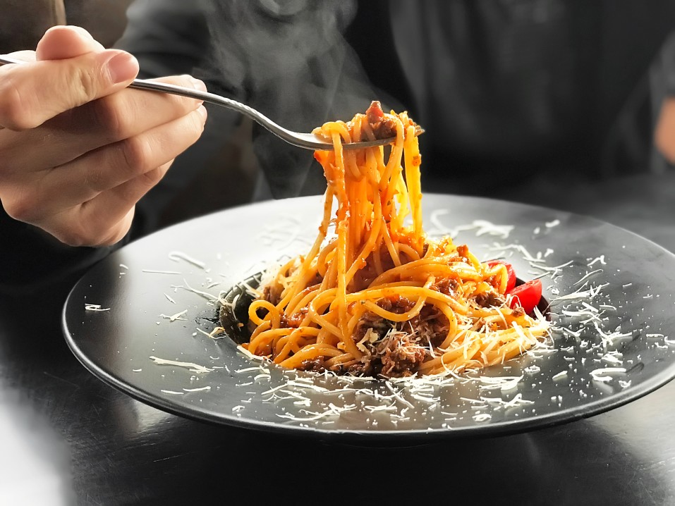 italian pasta with meat cheese and cherry tomatoes in black plate on black wooden table background t20 QajVVa